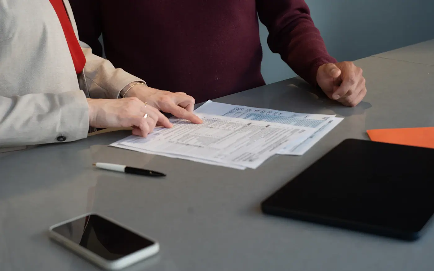 Two people reviewing financial paperwork together at a table